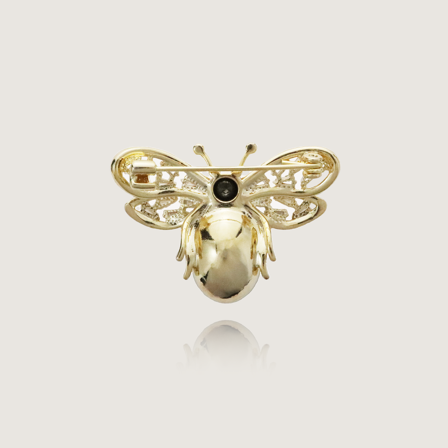 Elegant insect brooch featuring a deep green oval gem and filigree diamond detailing