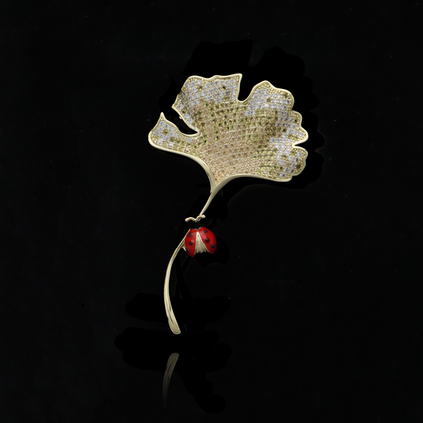 Gold ginkgo leaf brooch with pavé diamonds and a charming ladybug detail