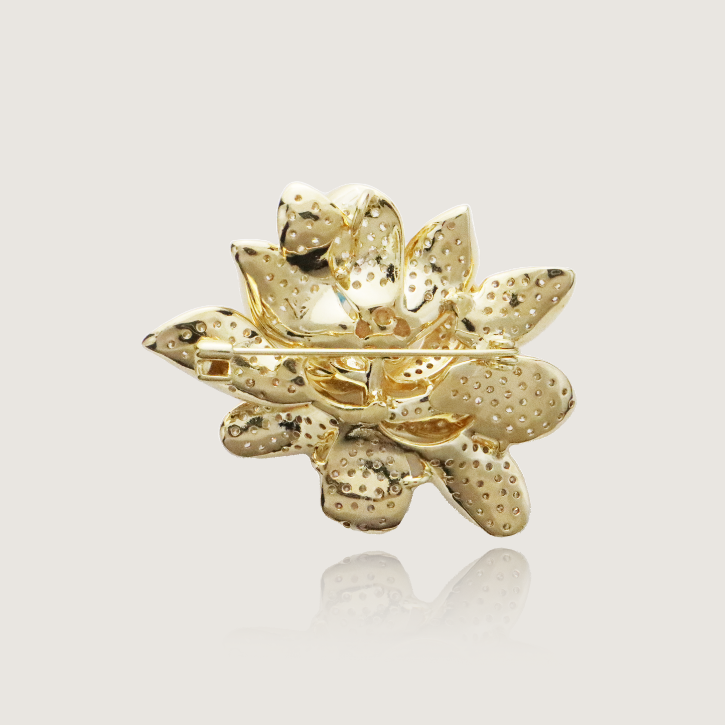 Luxurious gold flower brooch sparkling with diamonds and a prominent pearl