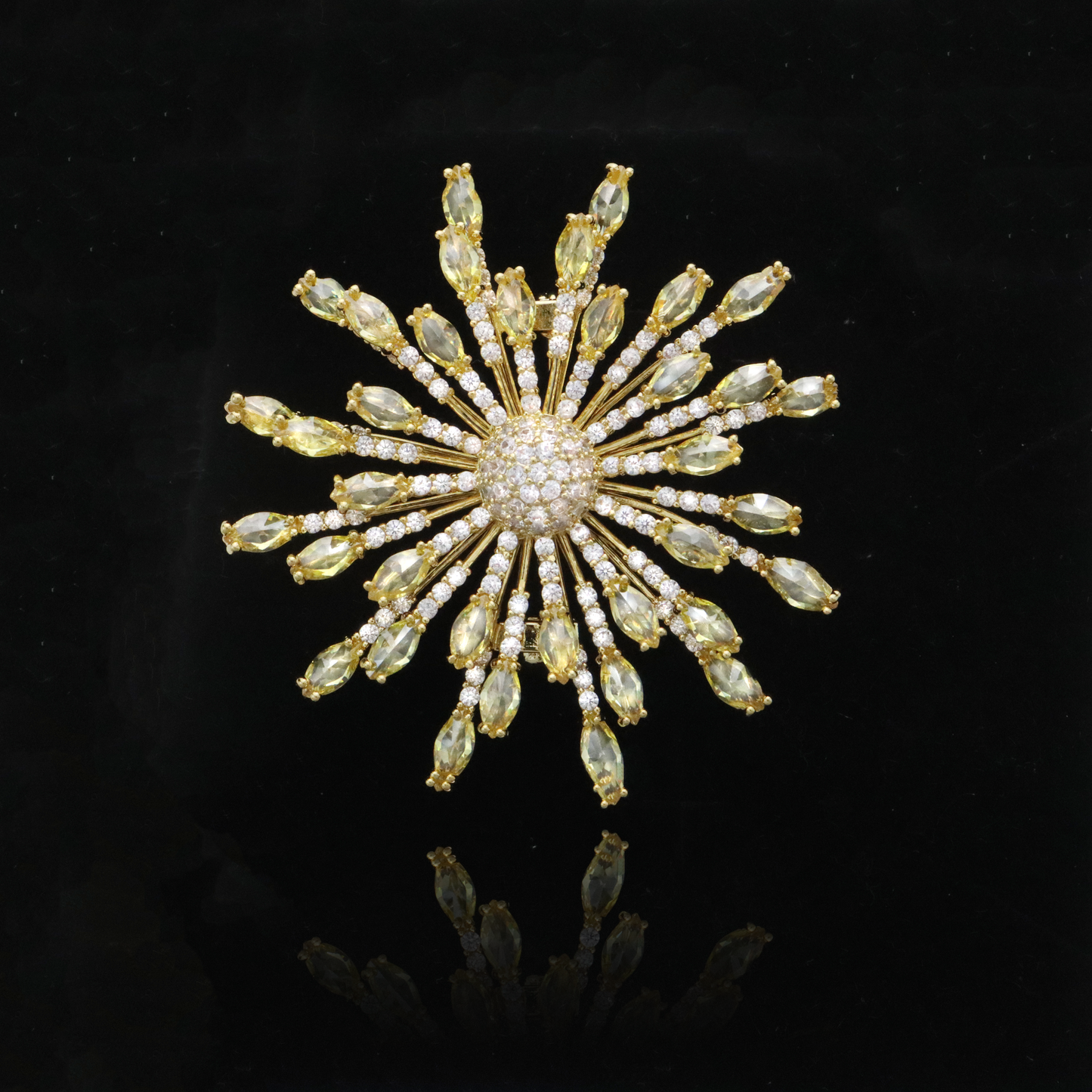 Radiant gold-toned starburst brooch with citrine-hued crystal rays