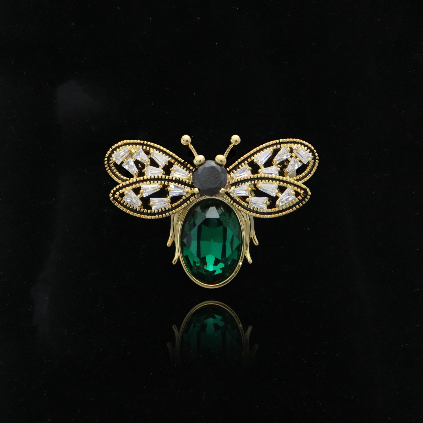 Art Deco-style bee pin with a vibrant green centerpiece and sparkling diamond accents