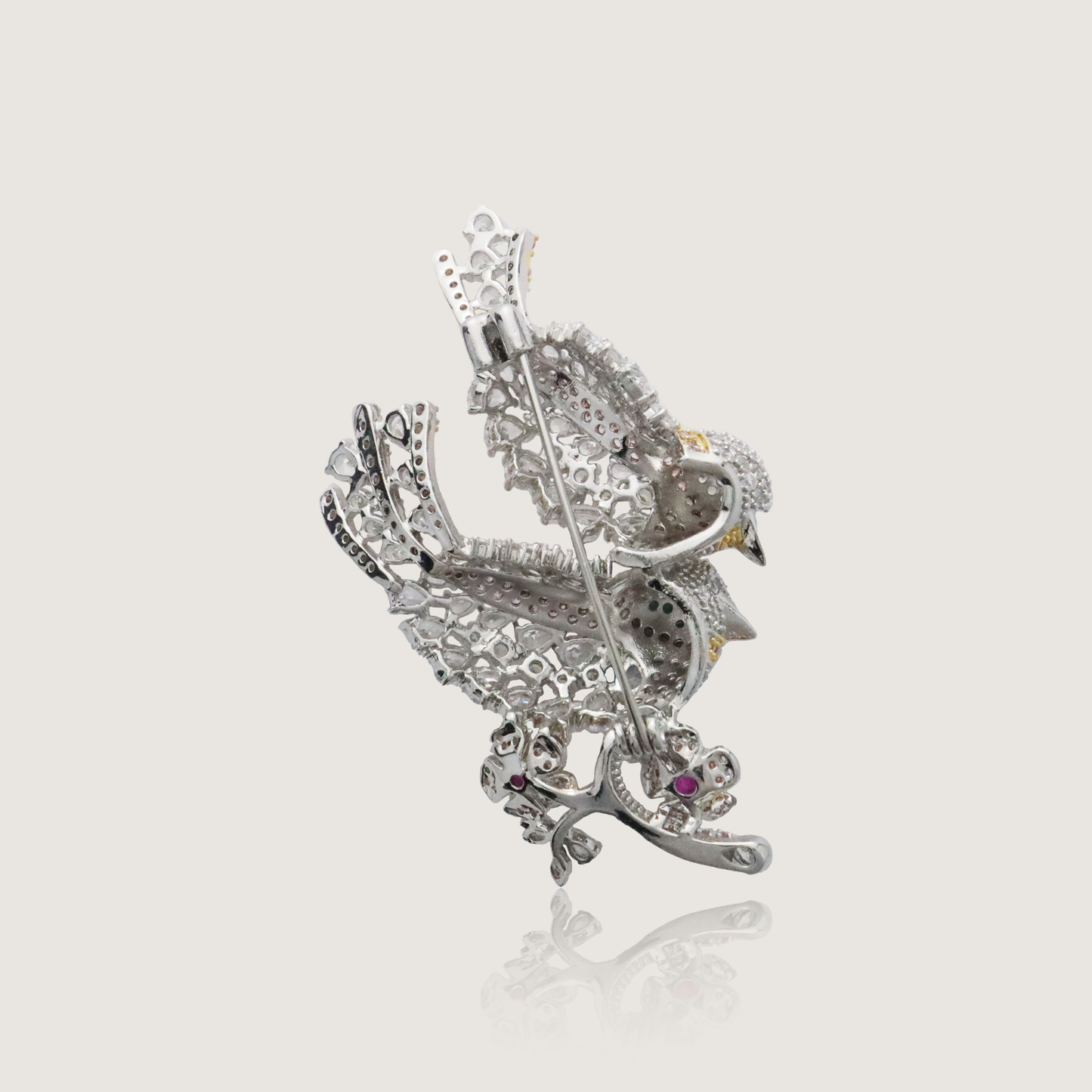 Ornate dual bird pin adorned with glittering stones and touches of color.