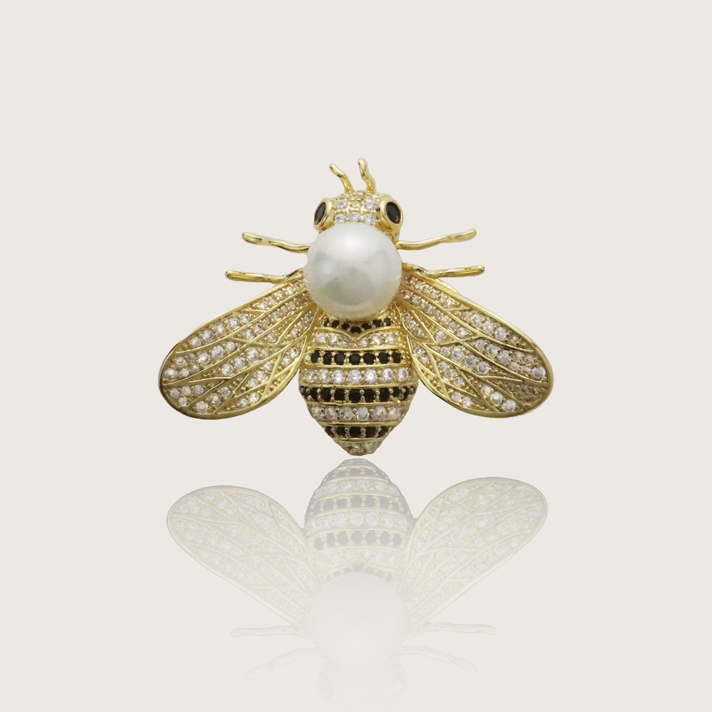 Gold bee brooch with cubic zirconia wings and a pearl body