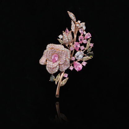 Exquisite rose brooch with pink and green gemstones on a gold stem