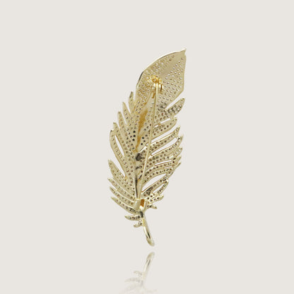 Glamorous diamond-studded gold feather brooch, an embodiment of opulence.