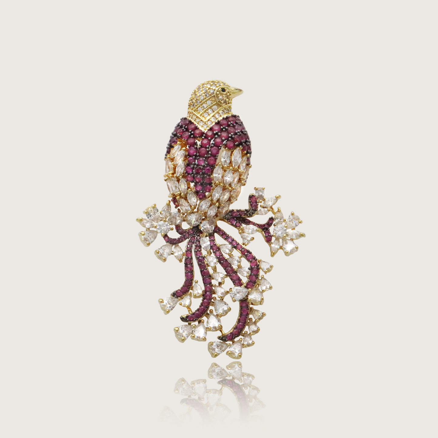 Glamorous ruby and diamond bird brooch with golden accents.