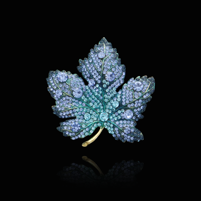 Lush sapphire and teal gemstone maple leaf brooch on a golden stem