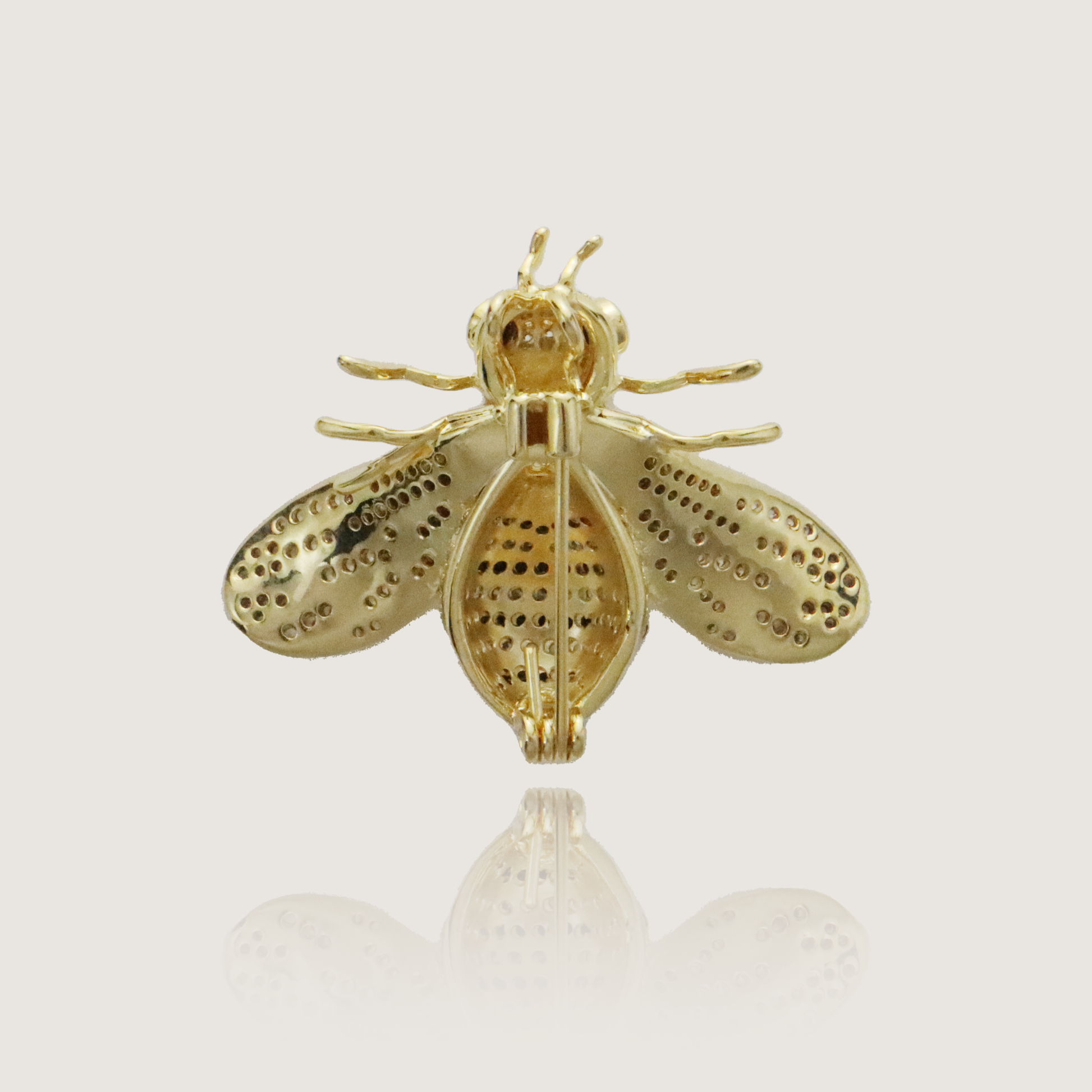 Nature-themed gold brooch featuring a cubic zirconia encrusted bee with a pear