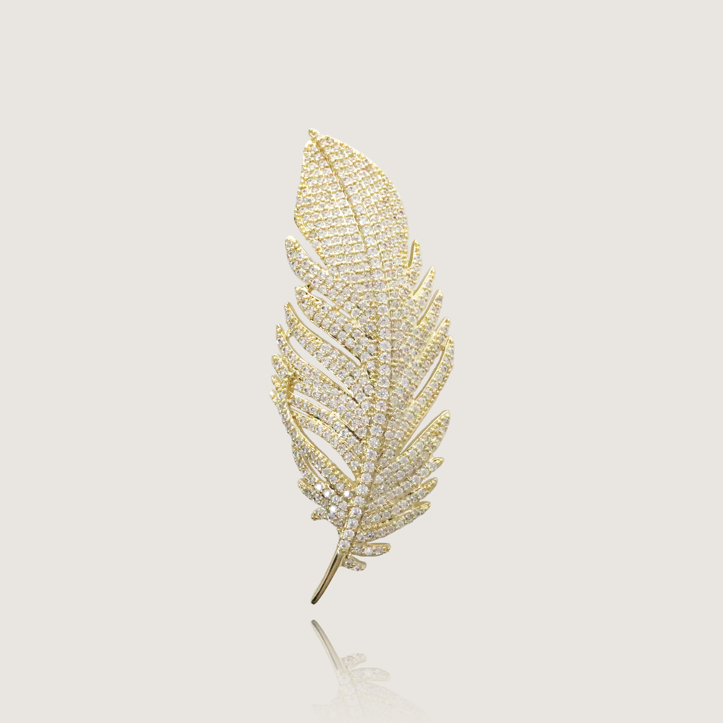 Regal feather-shaped pin glittering with diamonds set in polished gold