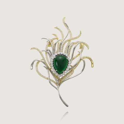 Sophisticated gold feather pin featuring a deep green gem and glittering diamond embellishments