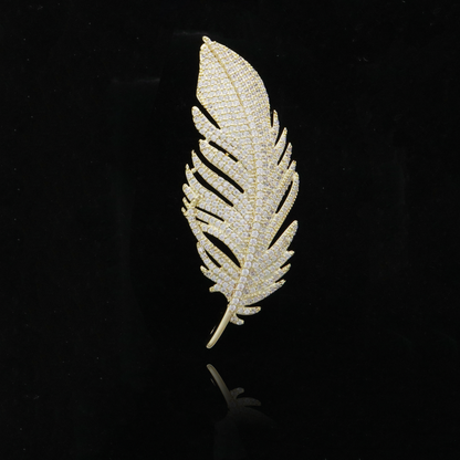 Stunning gold feather brooch with diamond detailing capturing a luxurious essence