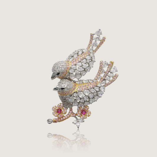 Twin crystal-encrusted birds brooch with golden and pink accents