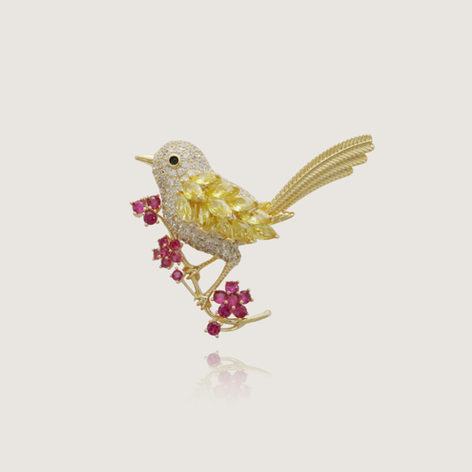 Vibrant jeweled bird brooch with yellow feathers and ruby flower accents